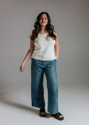Model wearing The Staple Tank in panna cotta, a neutral sleeveless cotton knit top with a relaxed fit