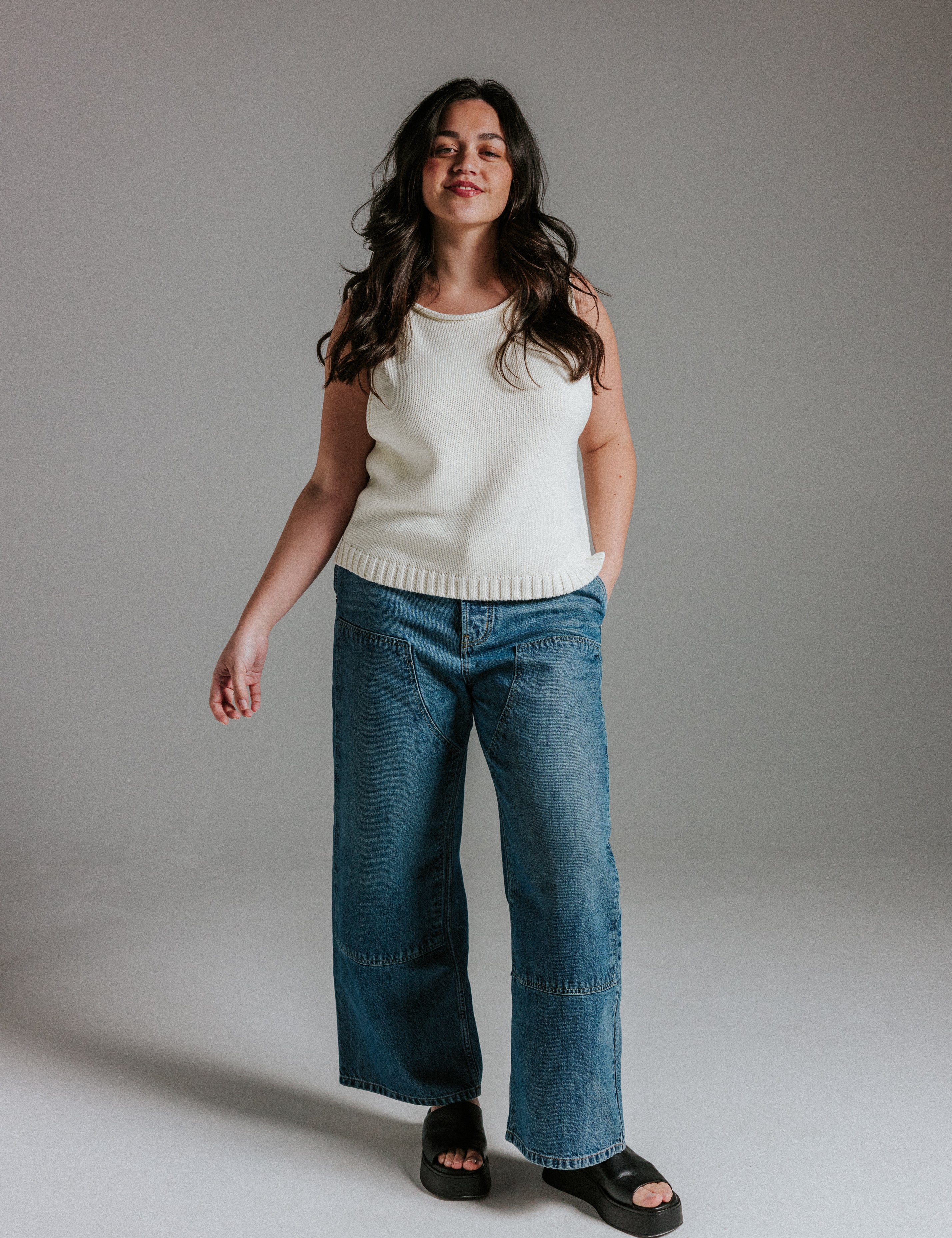 Model wearing The Staple Tank in panna cotta, a neutral sleeveless cotton knit top with a relaxed fit