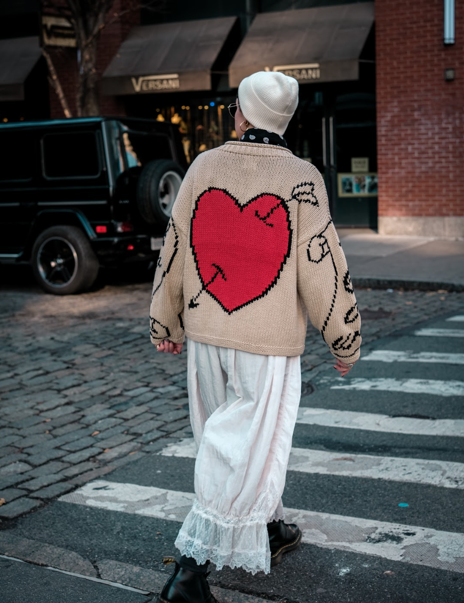 Lifestyle image of model wearing ecru Young Hearts hand knit jumper back view