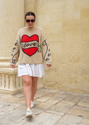 Lifestyle image of model wearing ecru Young Hearts hand knit jumper front view