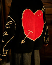 Close-up of black hand knit jumper showing stitch texture and craftsmanship