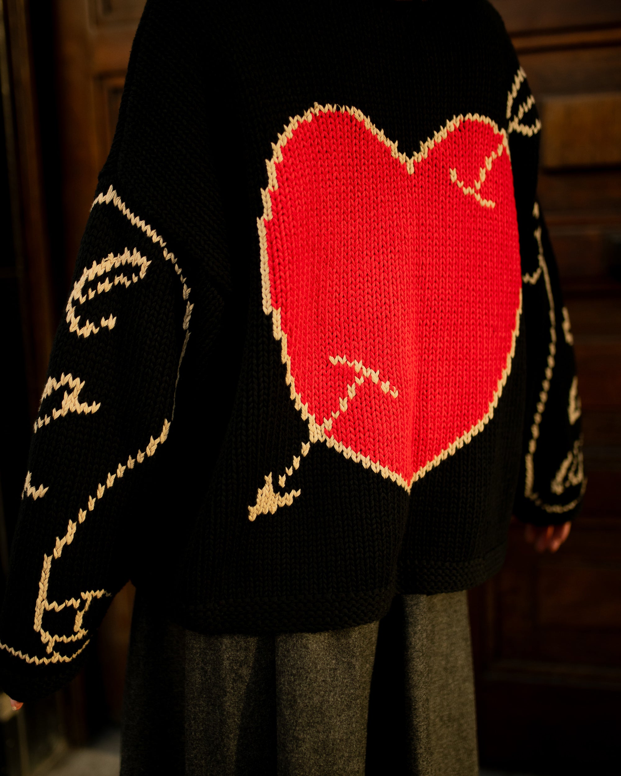 Close-up of black hand knit jumper showing stitch texture and craftsmanship
