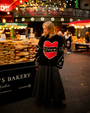 Model wearing black Young Hearts hand knit jumper outdoors in lifestyle setting