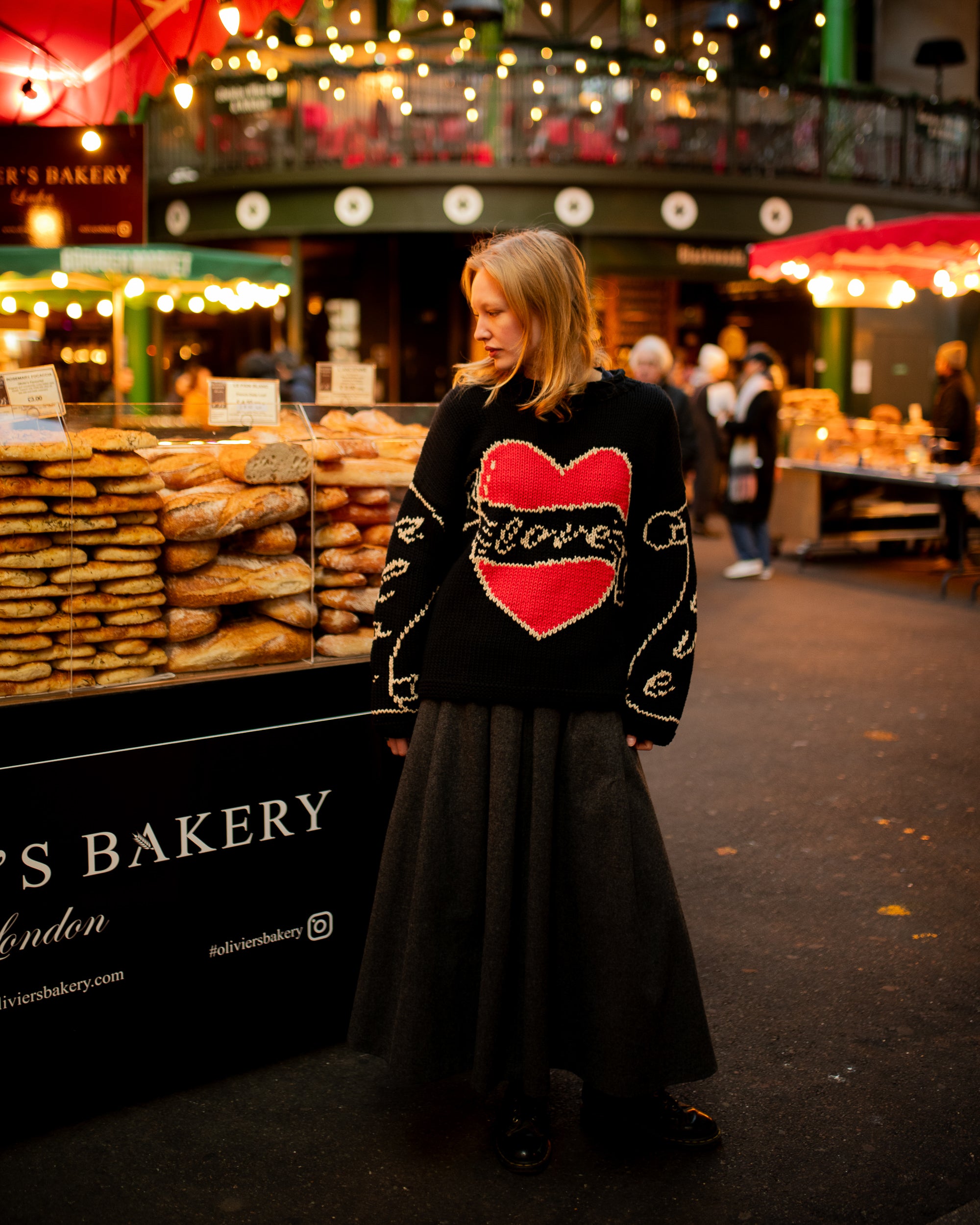 Model wearing black Young Hearts hand knit jumper outdoors in lifestyle setting
