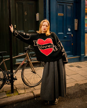 Styled lifestyle image of black Young Hearts hand knit jumper