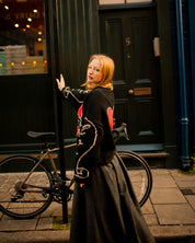 Side profile of model wearing black oversized hand knit jumper