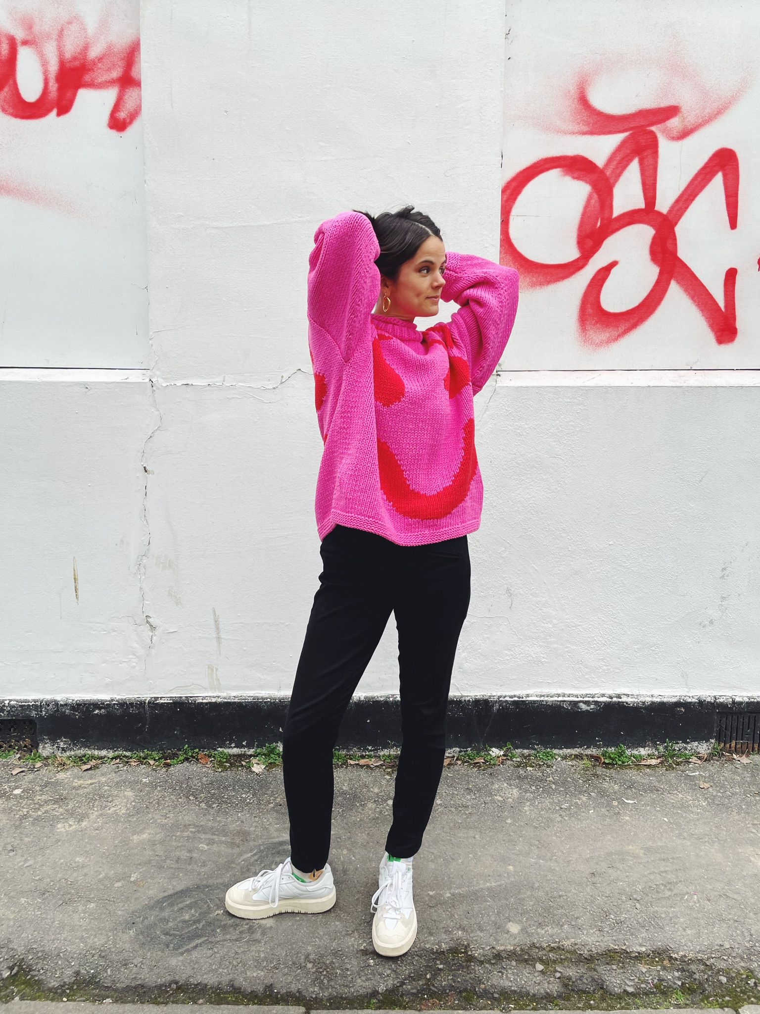 Side profile of oversized pink and red cotton jumper showing boxy fit