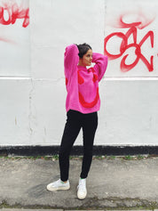 Side profile of oversized pink and red cotton jumper showing boxy fit
