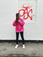 Lifestyle image of pink and red hand knit jumper in slow fashion styling