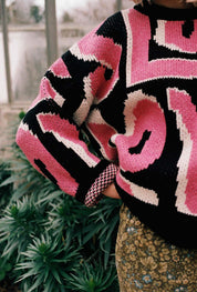 Pink Wild Love jumper by Slow Love showcasing its distinctive birdseye jacquard knit pattern.